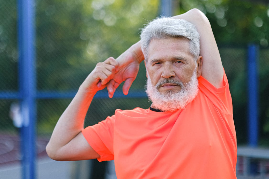 a middle-aged man stretching before a workout outdoors