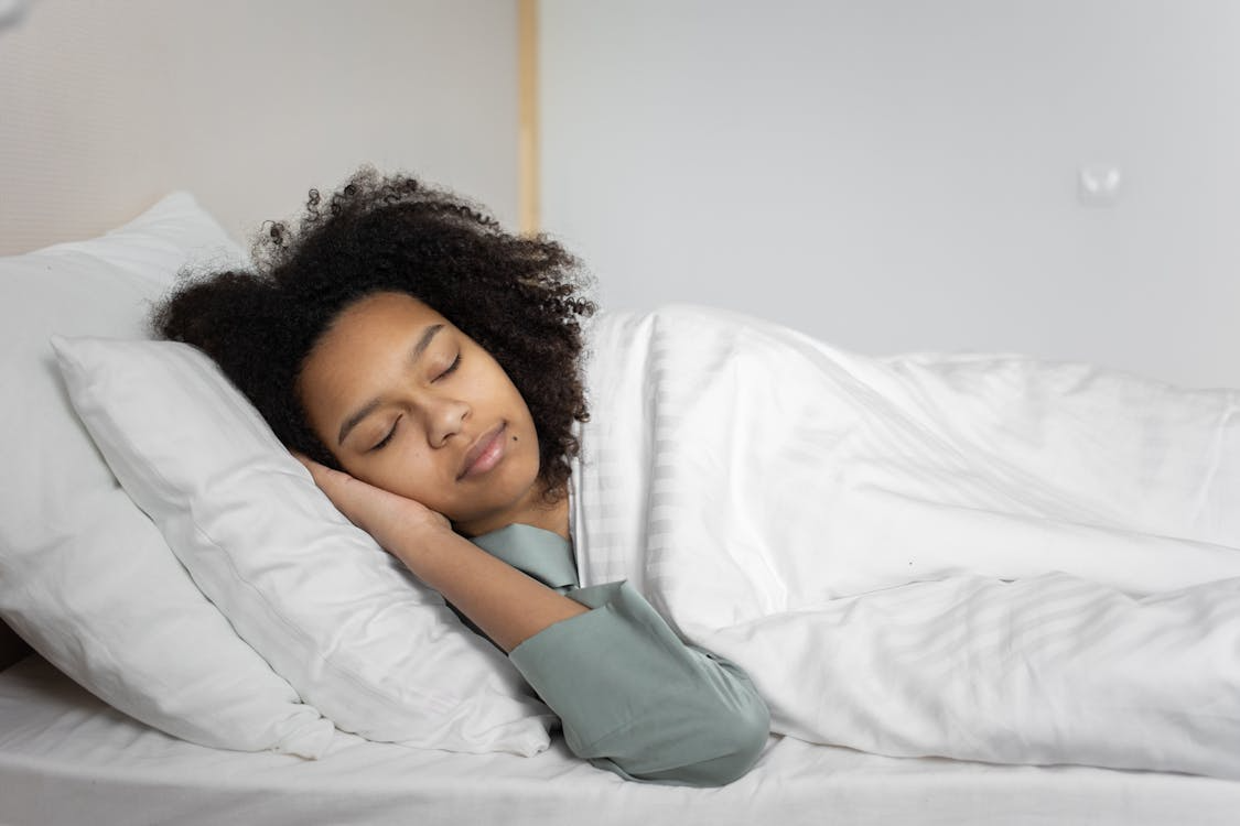 a person sleeping peacefully in a well-lit bedroom