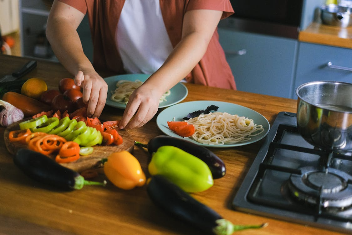  a person preparing a healthy meal with fresh vegetables at home
