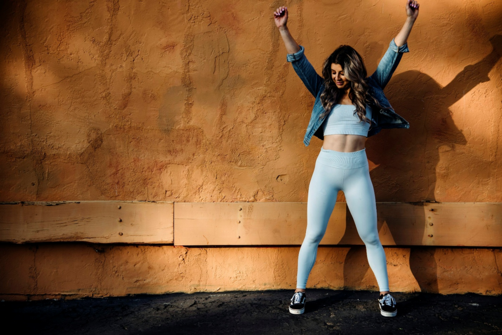 Woman standing with arms raised in an active pose