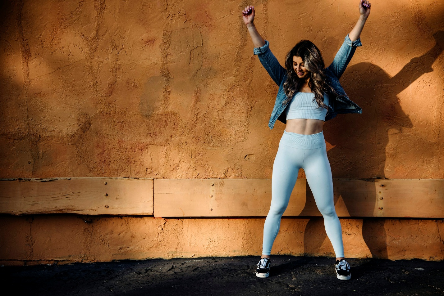 Woman standing with arms raised in an active pose