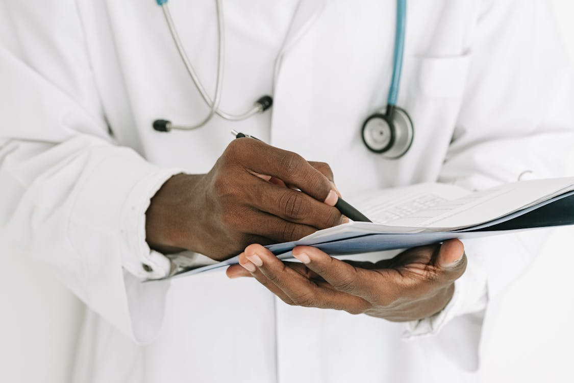 Medical provider writing notes on a clipboard