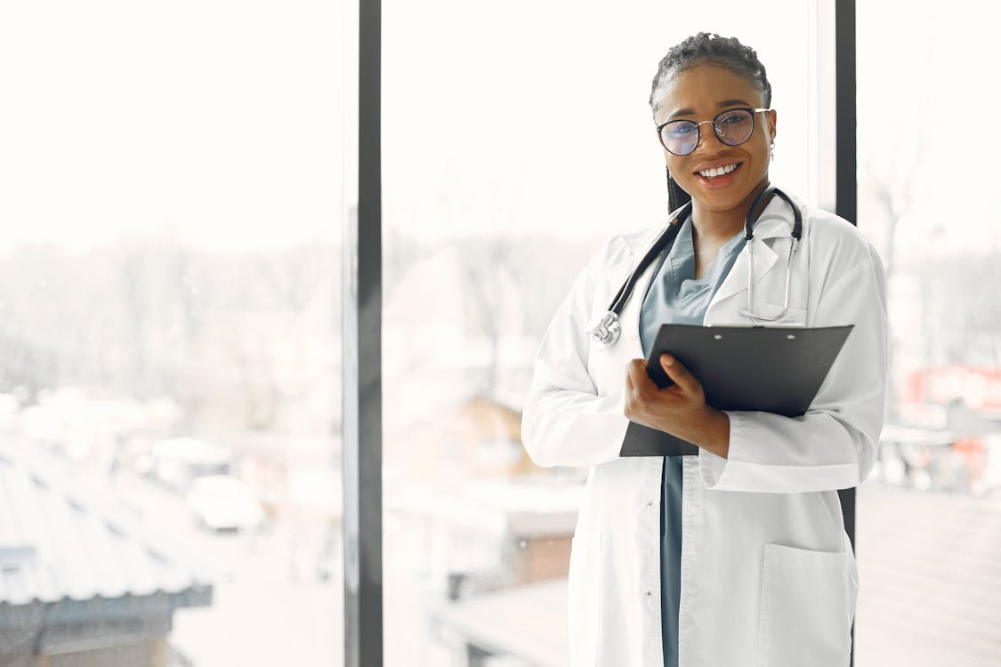 Medical provider smiling while holding a clipboard
