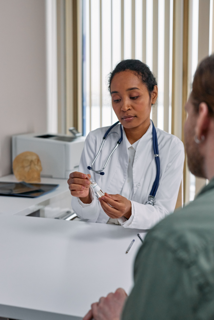 Female doctor showing a medication vial to a patient during a consultation