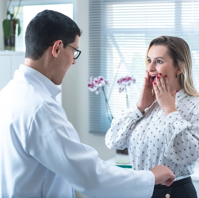 Woman with a surprised expression during a consultation with a male doctor in a clinic