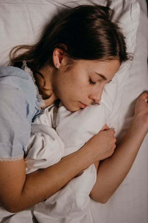 Young woman sleeping peacefully on a white pillow